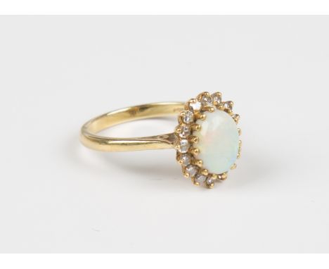 An 18ct gold, opal and diamond oval cluster ring, claw set with the oval opal within a surround of circular cut diamonds, wei