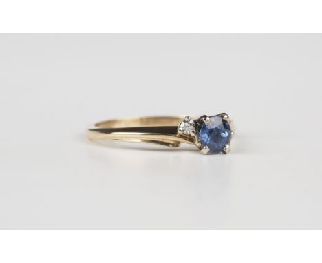 A 14ct gold, sapphire and diamond three stone ring, claw set with the circular cut sapphire between circular cut diamond sing