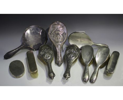 An Edwardian silver mounted three-piece dressing table set, decorated in relief with crowned maiden bust portraits, irises an