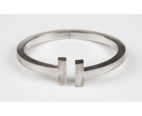 A Tiffany &amp; Co white gold oval sprung bangle with T-form terminals, detailed 'Tiffany &amp; Co Au 750 Germany', weight 28