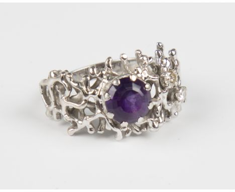 A white gold, amethyst and diamond ring, claw set with a circular cut amethyst and two circular cut diamonds in a pierced abs