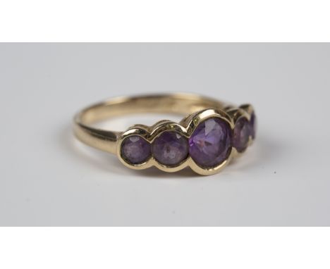 A 9ct gold and amethyst five stone ring, mounted with a row of graduated circular cut amethysts, weight 2.6g, ring size appro