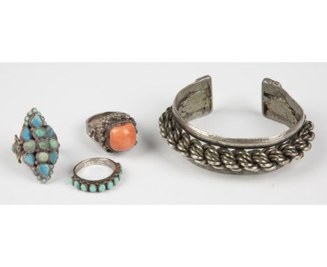 A Tibetan coral set ring, an Indian turquoise set cluster ring, a Native American turquoise set ring, detailed '925', and a p