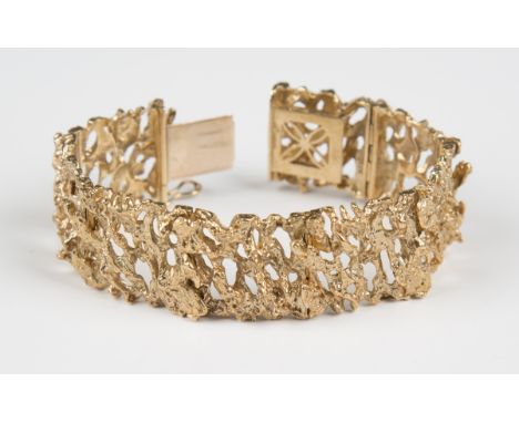 A 9ct gold panel link bracelet with a textured finish, cast and pierced in an abstract design, weight 58.6g, length 19cm, on 