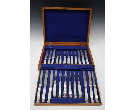 A set of twelve late Victorian silver and mother-of-pearl dessert knives and forks with decorated ferrules and terminals, She