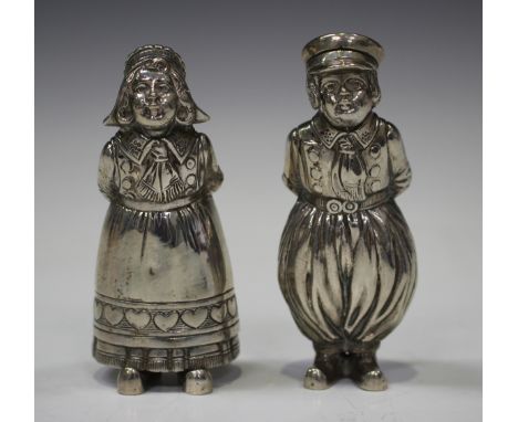 A pair of Dutch .800 silver novelty pepper casters, modelled as a boy and girl in traditional costume leaning forward for a k