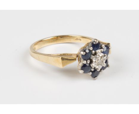 An 18ct gold, sapphire and diamond seven stone cluster ring, mounted with a circular cut diamond within a surround of six cir