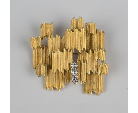 An 18ct gold and diamond brooch in an abstract design, mounted with a row of three circular cut diamonds, detailed '750', wei