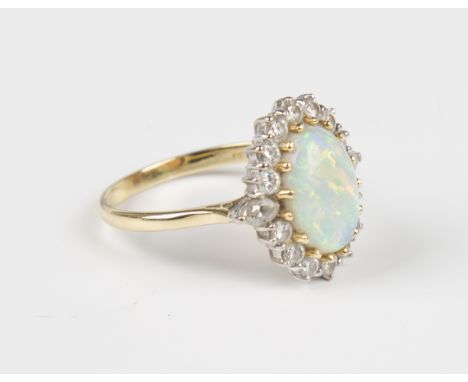 An 18ct gold, opal and diamond oval cluster ring, claw set with the oval opal within a surround of circular cut diamonds with