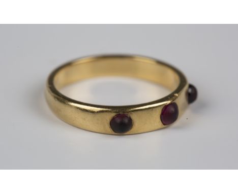 A gold and garnet three stone ring, mounted with a row of three cabochon garnets, detailed 'JB', weight 3.3g, ring size appro