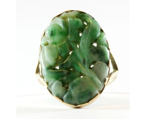 A yellow metal (tested minimum 9ct gold) carved jade set ring, (R).