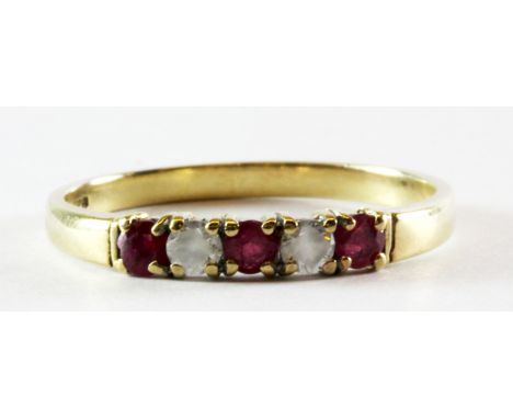 A 9ct yellow gold ruby and white stone half eternity ring, (N).