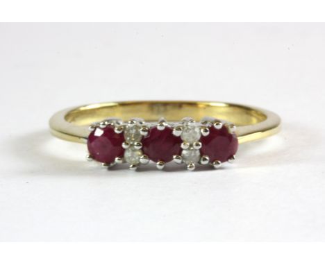 A 9ct yellow gold ruby and diamond set ring, (N.5).