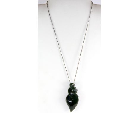 A carved nephrite jade pendant on a silver chain, pendant L. 6.5cm.
