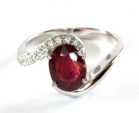 A 925 silver crossover ring set with an oval cut ruby and white stones, (P.5).