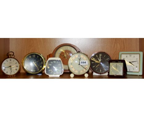 A collection of vintage alarm clocks and one mantle clock.