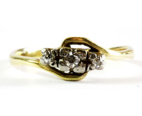 An 18ct yellow gold three diamond set ring, (K).