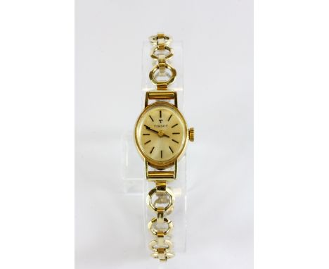A vintage lady's Tissot 9ct yellow gold wrist watch with a gold plated strap.