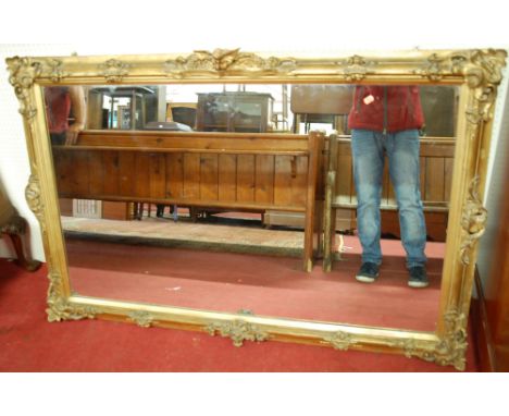 A late 19th century giltwood and gesso rectangular wall mirror, the surround floral decorated with central winged putti, 98x1