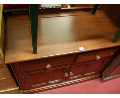 An Ercol dark elm ledgeback double door side cupboard having twin upper drawers