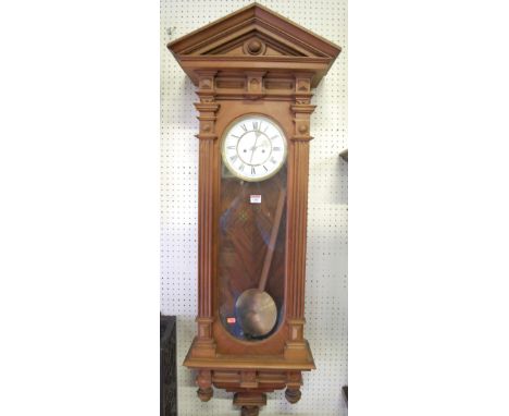 A large early 20th century walnut Vienna style architectural drop trunk wall clock, having white enamelled dial with pendulum