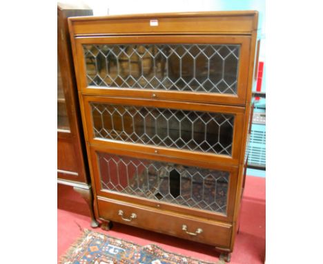 A Globe Wernicke style 1930s walnut and lead glazed three-tier stacking bookcase, with long lower drawer (some glazing panels