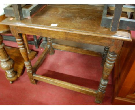 An antique joined oak side table raised on ring turned and square cut supports