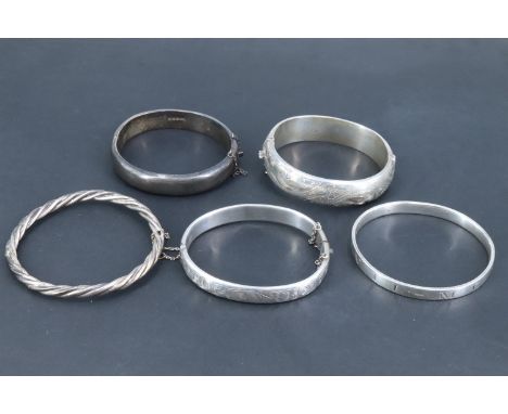 A Charles Horner silver hinged bangle, two other similar bangles, another of cable form and a Millennium solid silver oval ba