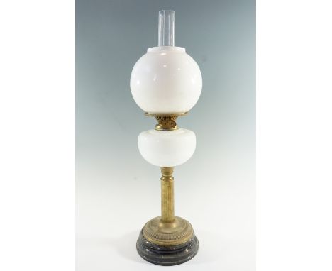 A Victorian / early 20th Century columnar brass and opaque glass oil lamp, having a duplex coronet burner and opaque globular