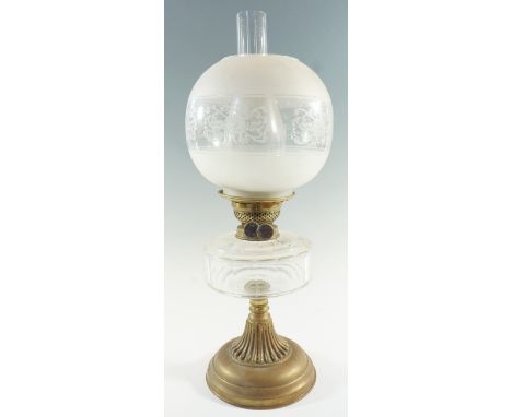 An early 20th Century columnar brass and faceted glass oil lamp, having a duplex coronet burner and enamelled and frosted glo