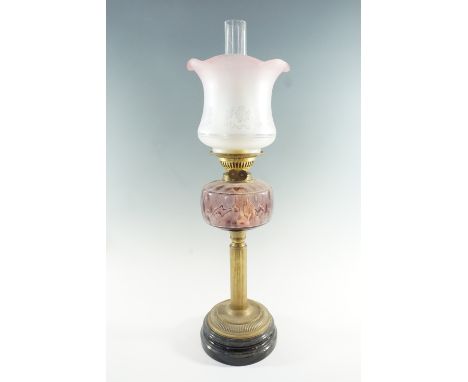 A Victorian columnar brass and amethyst glass oil lamp, having a duplex coronet burner and mildly achromatising crinoline edg