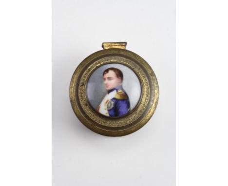 A mid to late 19th Century gilt metal ring box, of cylindrical form having embossed decoration and bearing a bezel set enamel