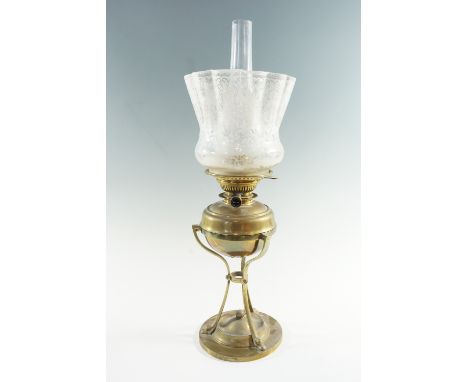 An early 20th Century brass oil lamp, having a triform base holding a removable font with a central draught 'Messengers' burn