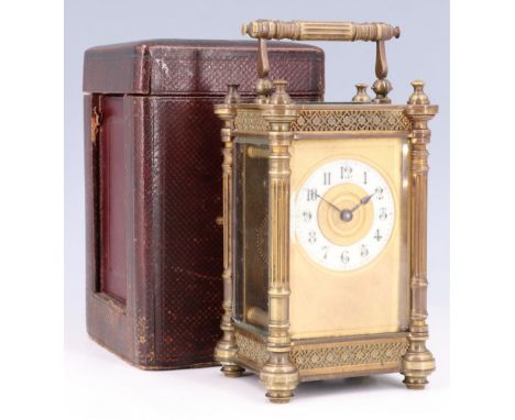 A late 19th / early 20th Century brass carriage clock, having a porcelain chapter ring and brass case having flowerhead diape