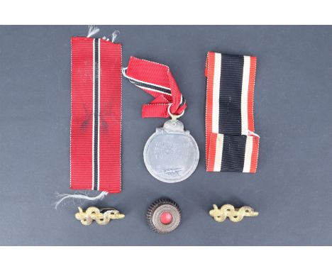 A German Third Reich Eastern Front Medal (a/f), together with two medical branch epaulette badges, a cockade and medal ribbon