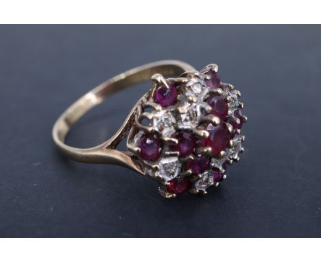 An ruby and diamond cluster dress ring, having a central 3.5 mm brilliant ruby, above and surrounded by four rubies and two i