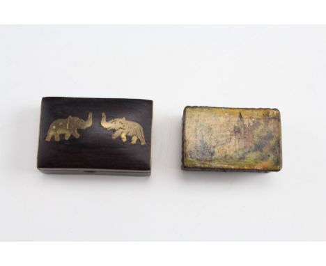 A late 19th Century papier-mâché snuff box, the lid painted in depiction of a castle, together with another having inlaid bra