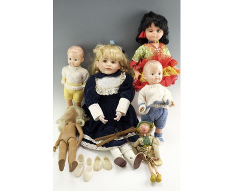 A large vintage bisque-headed doll together with a group of composition dolls and a wooden puppet, former 65 cm