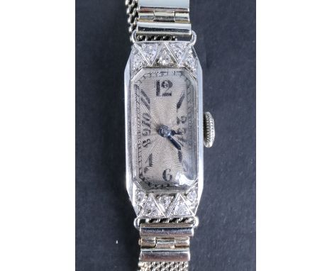 A 1920s lady's Art Deco precious white metal (stamped platinum) and diamond wristlet watch, the slender oblong frosted silver