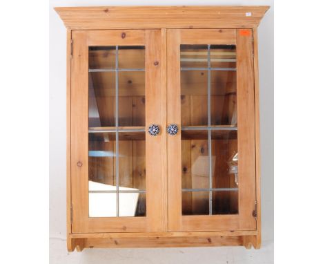 A country pine 19th century revival pine wood wall hanging glazed display cabinet. The cabinet featuring two glazed doors to 