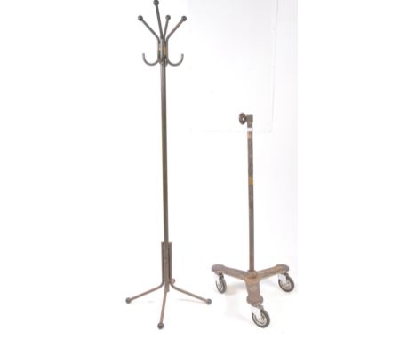 A mid 20th century metal studio spotlight stand base, alongside a metal coat rack. The spotlight stand having a cast iron bas