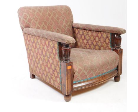 A 1930s Art Deco oak upholstered club armchair. Having turned baluster elbow rest supports with cushioned back rest and seat 