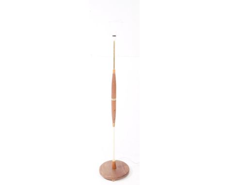 British Modern Design - A mid 20th century teak and brass floor standing standard lamp. Raised on a rounded base, with turned