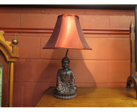 A modern Buddha figural lamp with red shade, 58cm tall