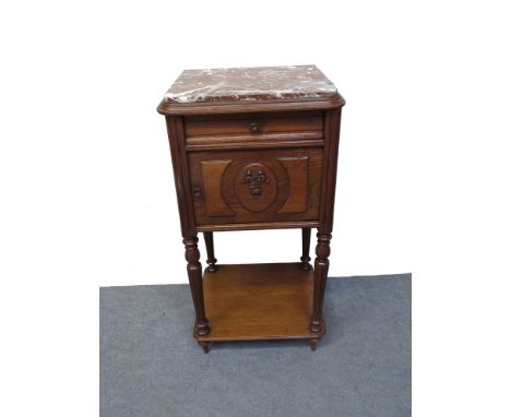 A 19th Century French oak two tier night stand the marble top over a single drawer and cupboard door with carved decoration o