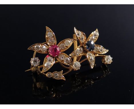 A gold diamond floral brooch set with central ruby and sapphire