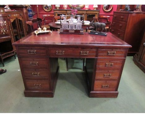A late Victorian mahogany twin pedestal writing desk the tooled leather writing surface over nine drawers, plinth base on cer