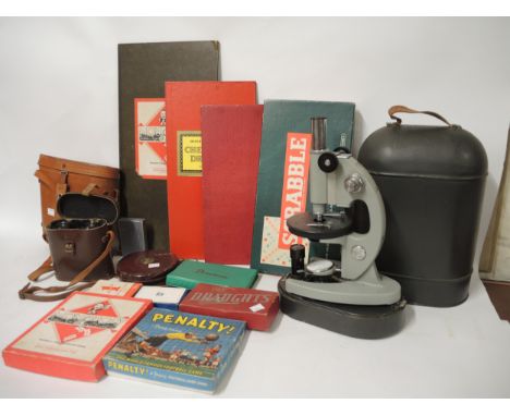 Russian microscope under metal dome with various lenses, pair of leather cased binoculars, another binocular case, leather ta