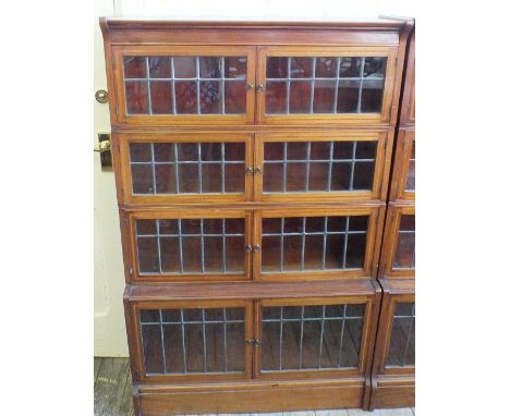A pair of William Baker & Co., Oxford, inlaid Mahogany leaded light four tier sectional bookcases, the lower tier being in cu