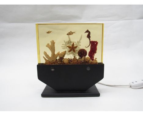 An aquarium table lamp, black painted metal base illuminating a cast resin block. 23cm x 20.5cm 